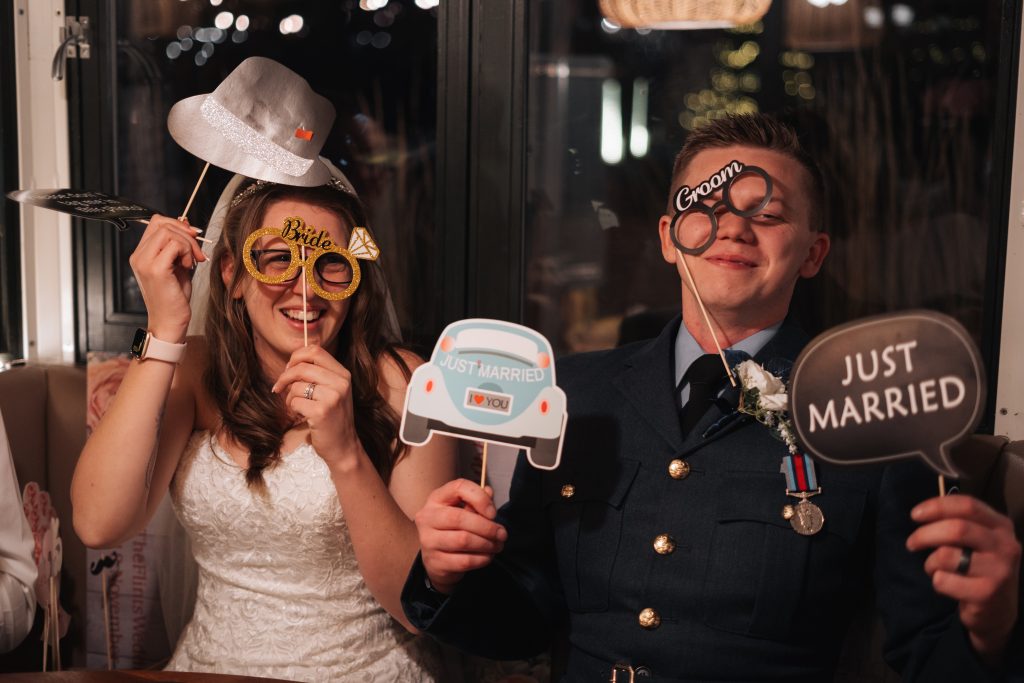 Bride and Groom using photography props to make a funny picture