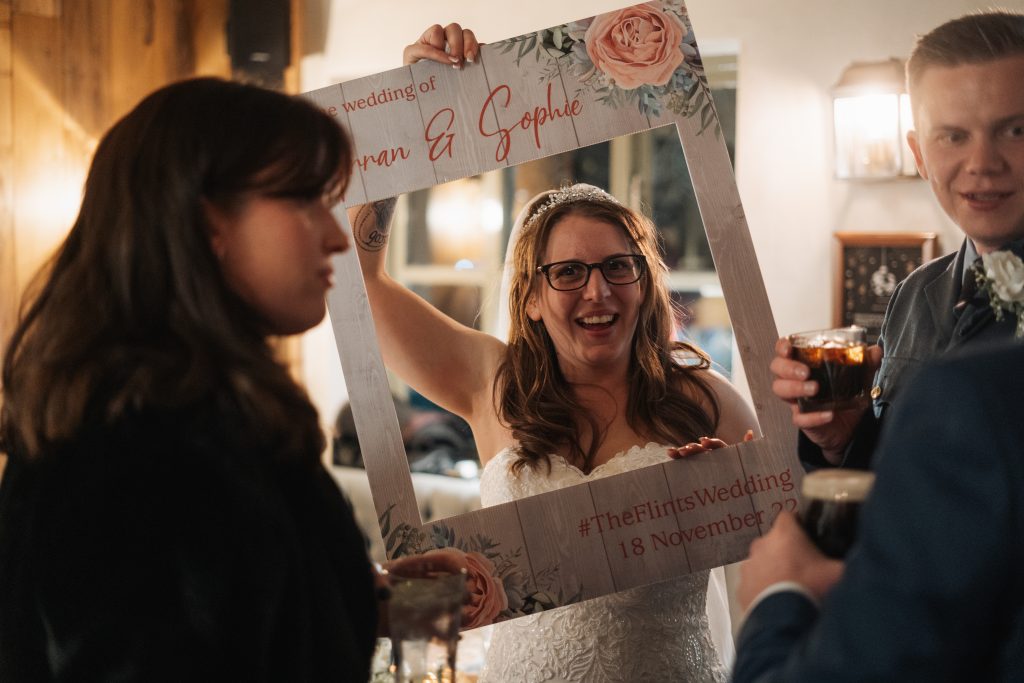 Bride using a wedding frame for a photo