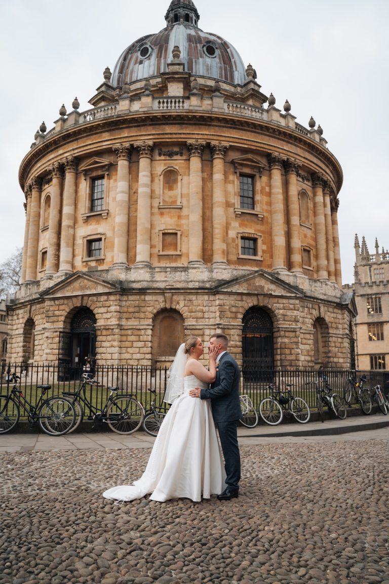 Bride and Groom kissing in front of the Radcliffe Camera in Oxford City centre.