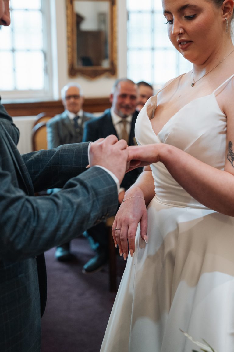 Groom putting the wedding ring on the bride
