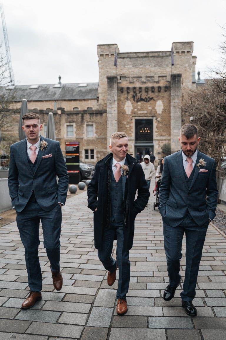 Groom and his two best men walking in front of the camera