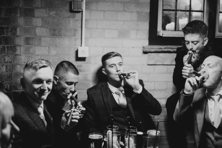 A group of men lighting a cigar